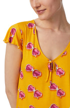 A lady wearing yellow cap sleeve phoebe pj set in sunny honey.