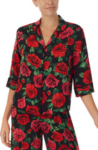 A lady wearing a black short sleeve top with red rose flowers pattern.