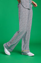 A lady wearing a long pj pant with black and white feline pride pattern.