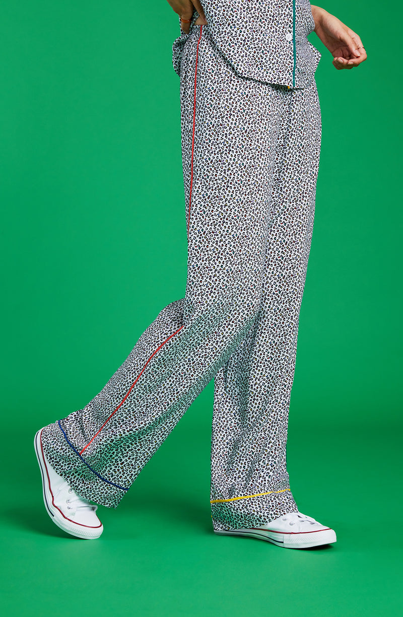 A lady wearing a long pj pant with black and white feline pride pattern.
