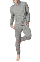 A man wearing a grey long sleeve unisex reese hoodie with pride stripes in side.