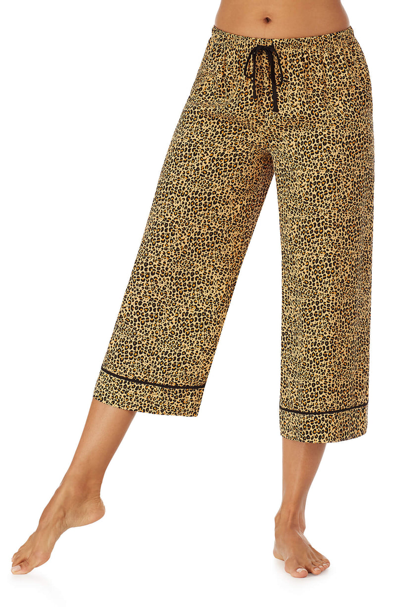 Bottom part f a girl wearing a crop pant with leopard skin pattern.