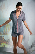 A girl wearing a grey colour short sleeve pajama set with white short stripes.