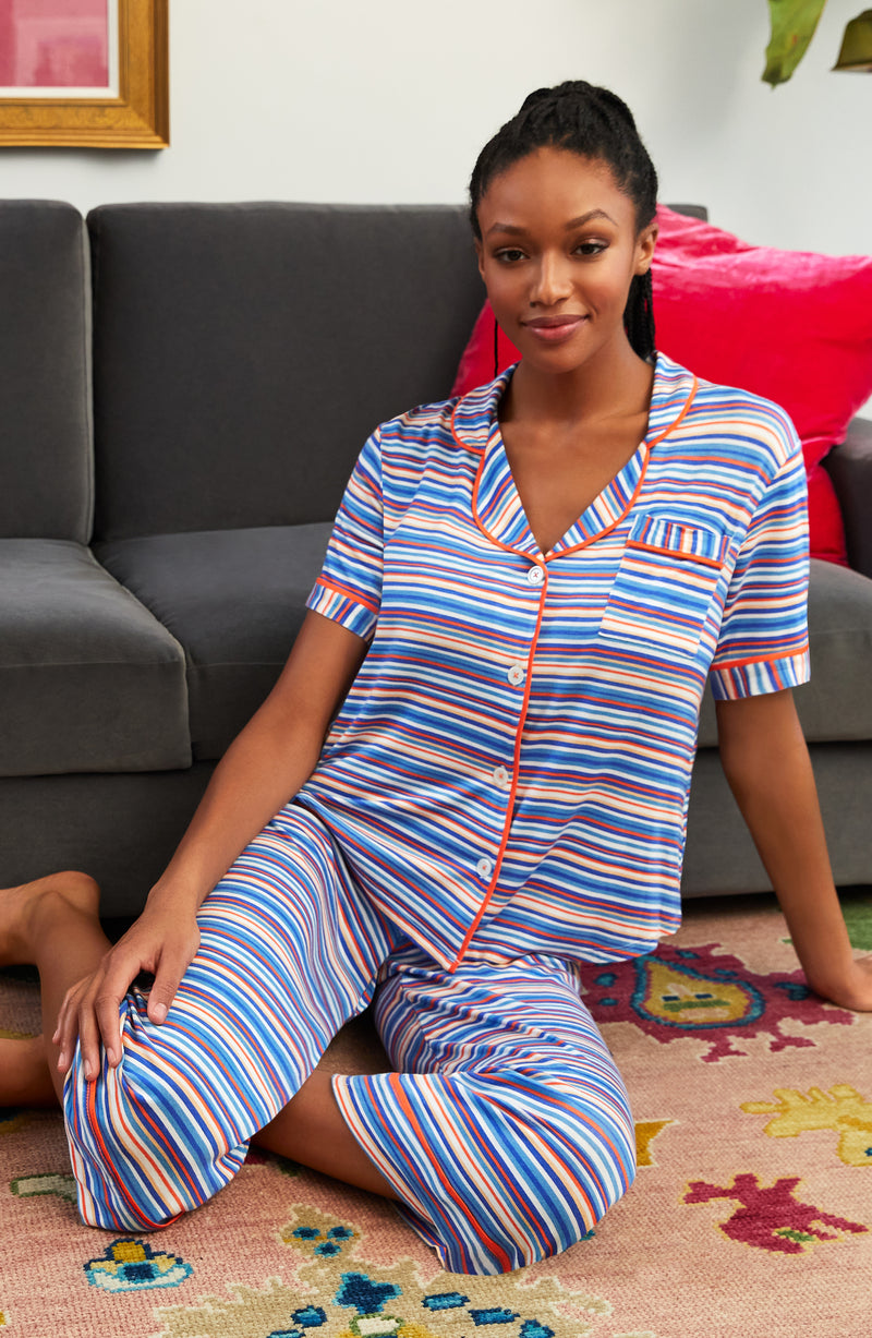 A lady wearing a short sleeve crop pajama set with azul stripes.