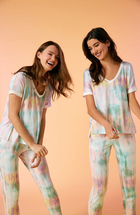 2 girls wearing short sleeve pajama sets with multi colour tie dye design.