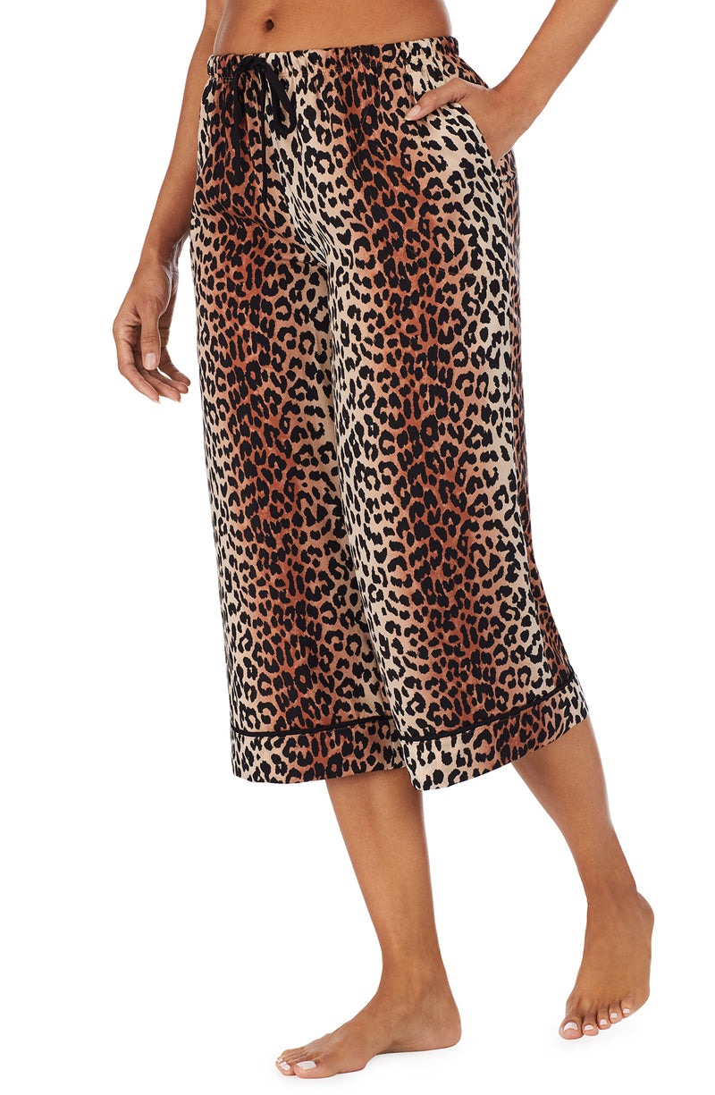 Bottom part f a girl wearing a short sleeve crop pant with leopard skin pattern.