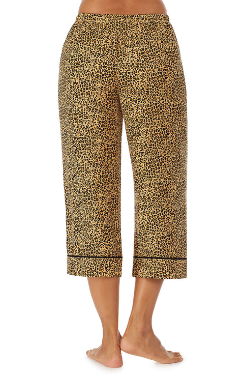 Bottom part f a girl wearing a crop pant with leopard skin pattern.