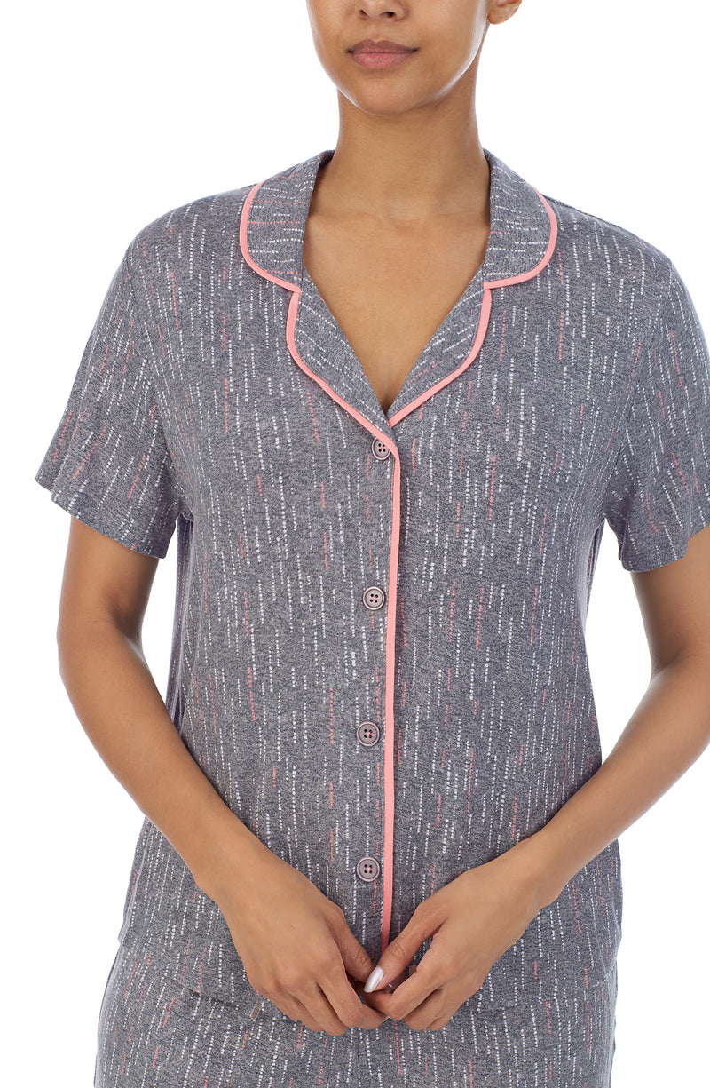 Upper part of girl's body wearing a grey colour short sleeve pajama set with white short stripes.