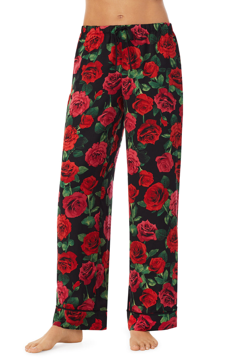 A lady wearing a black pant with red rose flowers pattern.