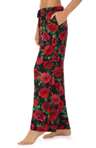 A lady wearing a black pant with red rose flowers pattern.