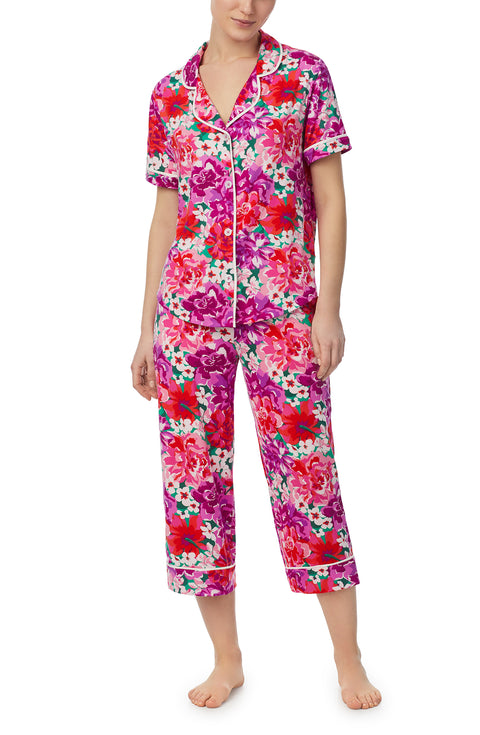 A lady wearing purple short sleeve soho pj set with magenta meadow print.