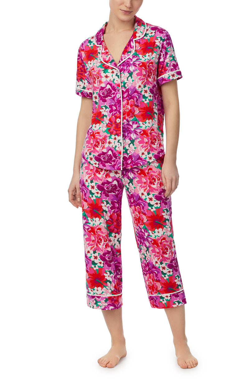 A lady wearing purple short sleeve soho pj set with magenta meadow print.