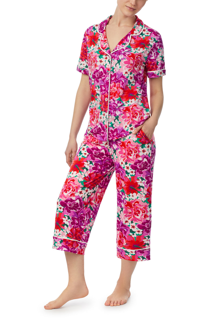 A lady wearing purple short sleeve soho pj set with magenta meadow print.