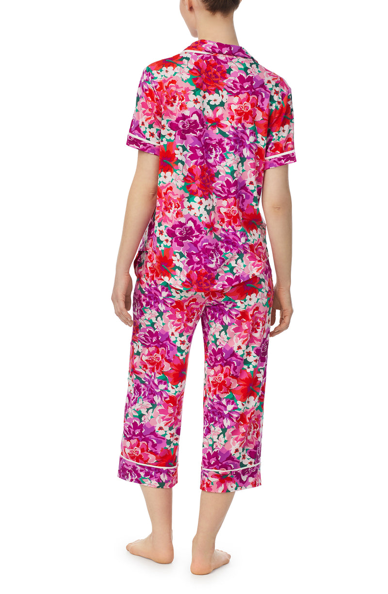 A lady wearing purple short sleeve soho pj set with magenta meadow print.