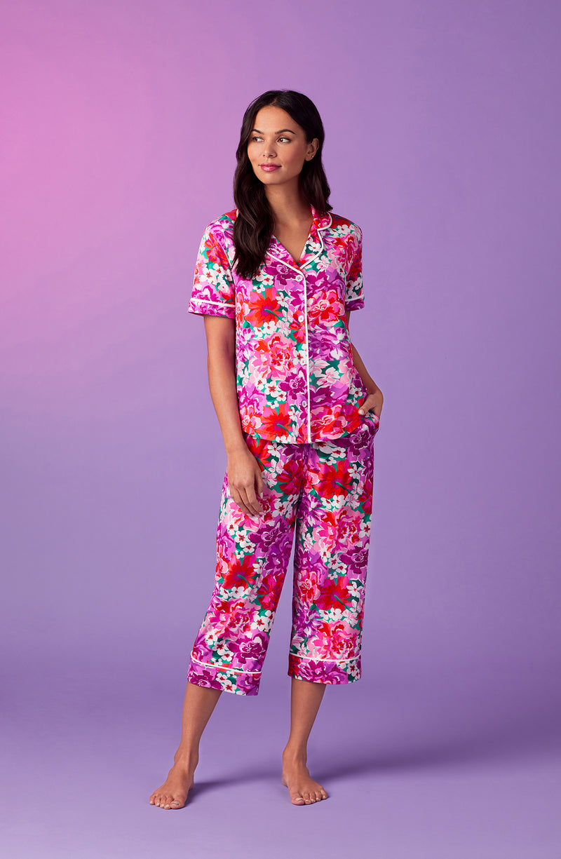 A lady wearing purple short sleeve soho pj set with magenta meadow print.