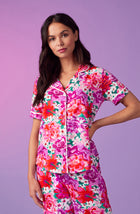 A lady wearing purple short sleeve soho pj set with magenta meadow print.