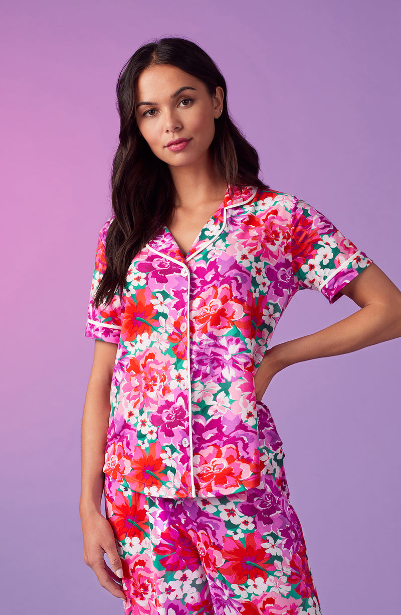 A lady wearing purple short sleeve soho pj set with magenta meadow print.