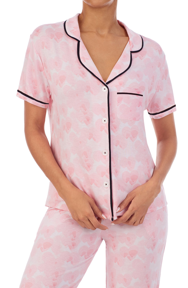 Upper part of a girl's body wearing a short sleeve top and crop pant pajama set with pink balloon design.