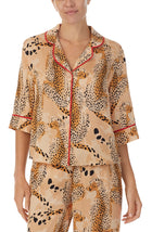 A lady wearing a tan elbow sleeve top with java jungle print.