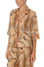 A lady wearing a tan elbow sleeve top with java jungle print.