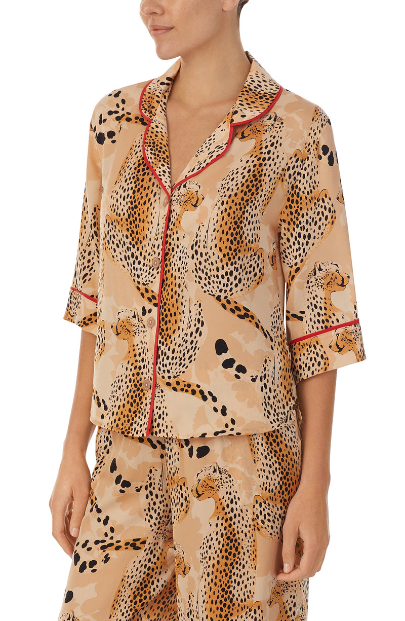 A lady wearing a tan elbow sleeve top with java jungle print.