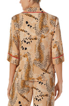 A lady wearing a tan elbow sleeve top with java jungle print.