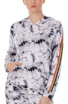 A lady wearing a long sleeve reese unisex hoodie with black and white tiedye with pride stripes in side.