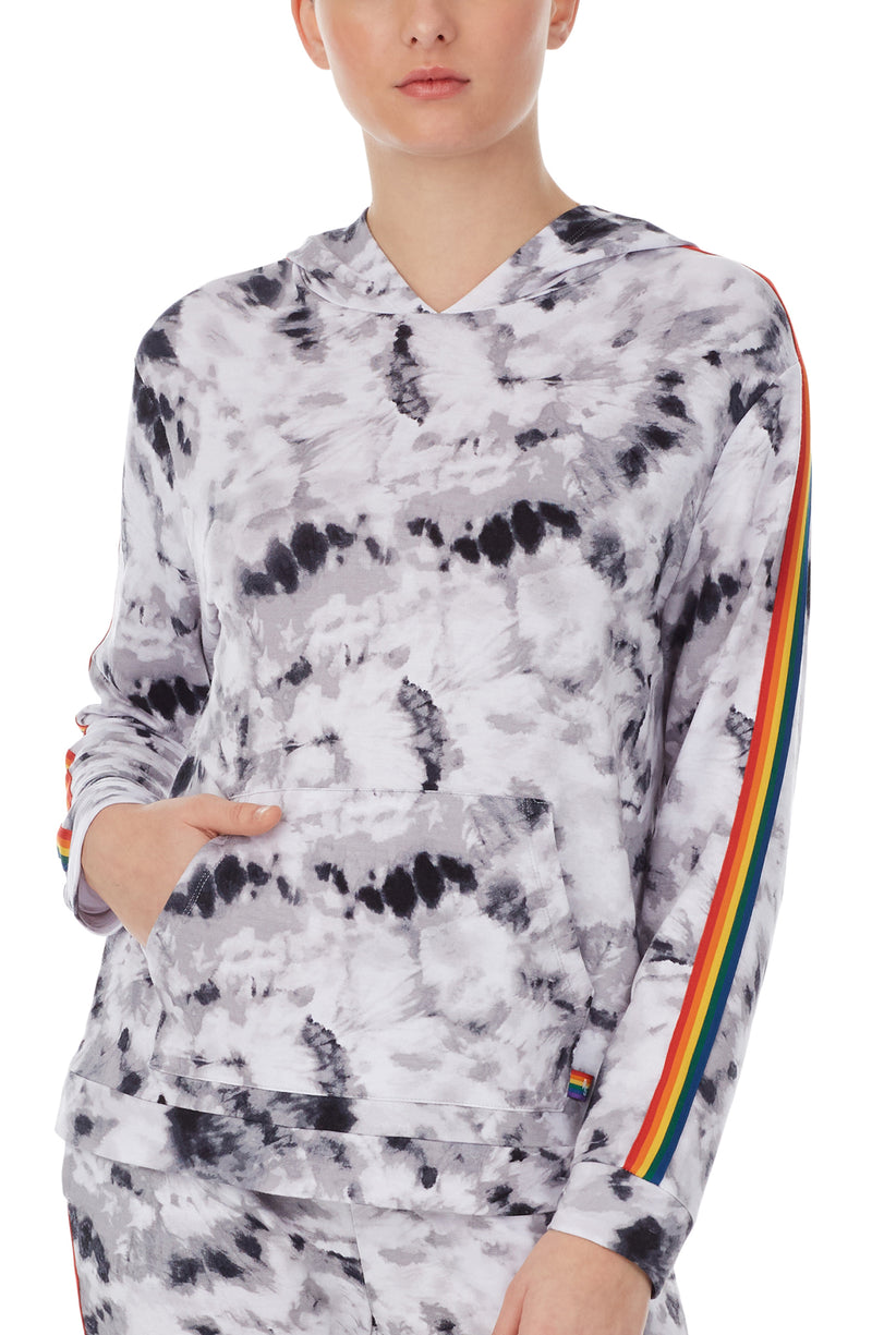 A lady wearing a long sleeve reese unisex hoodie with black and white tiedye with pride stripes in side.