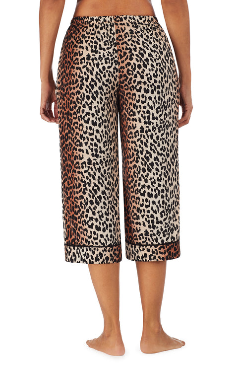 Bottom part f a girl wearing a short sleeve crop pant with leopard skin pattern.