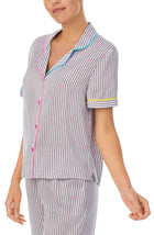 A lady wearing a short sleeve top with silver stripes.