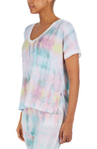 Upper body of a girl wearing short sleeve pajama sets with multi colour tie dye design.