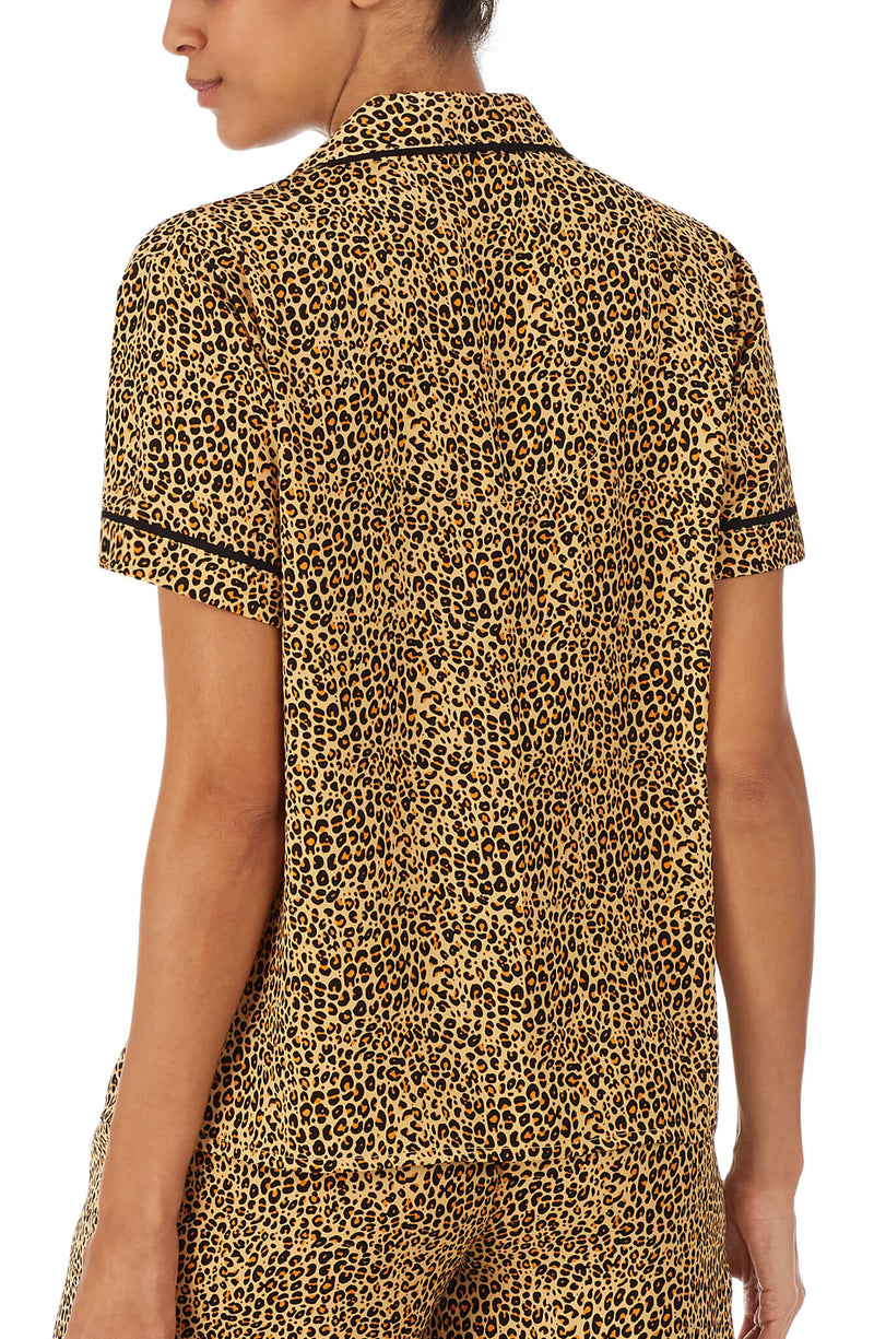 Upper part of a girl wearing short sleeve top with leopard skin design.