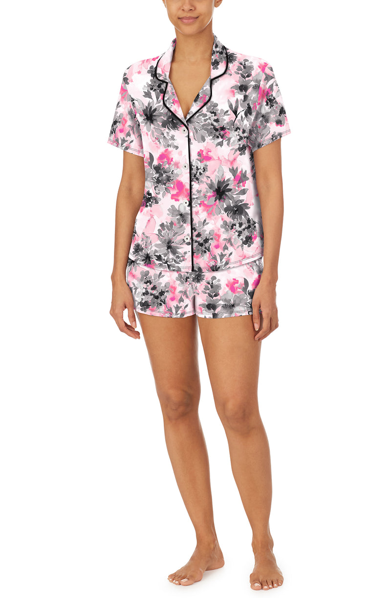 A lady wearing a short sleeve notch top and boxer pj set with pink watercolor floral pattern.