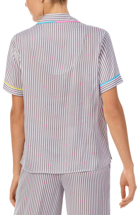 A lady wearing a short sleeve top with silver stripes.