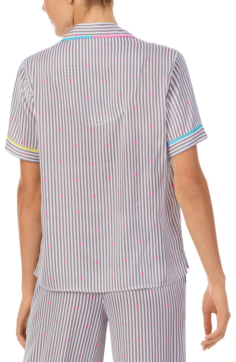 A lady wearing a short sleeve top with silver stripes.