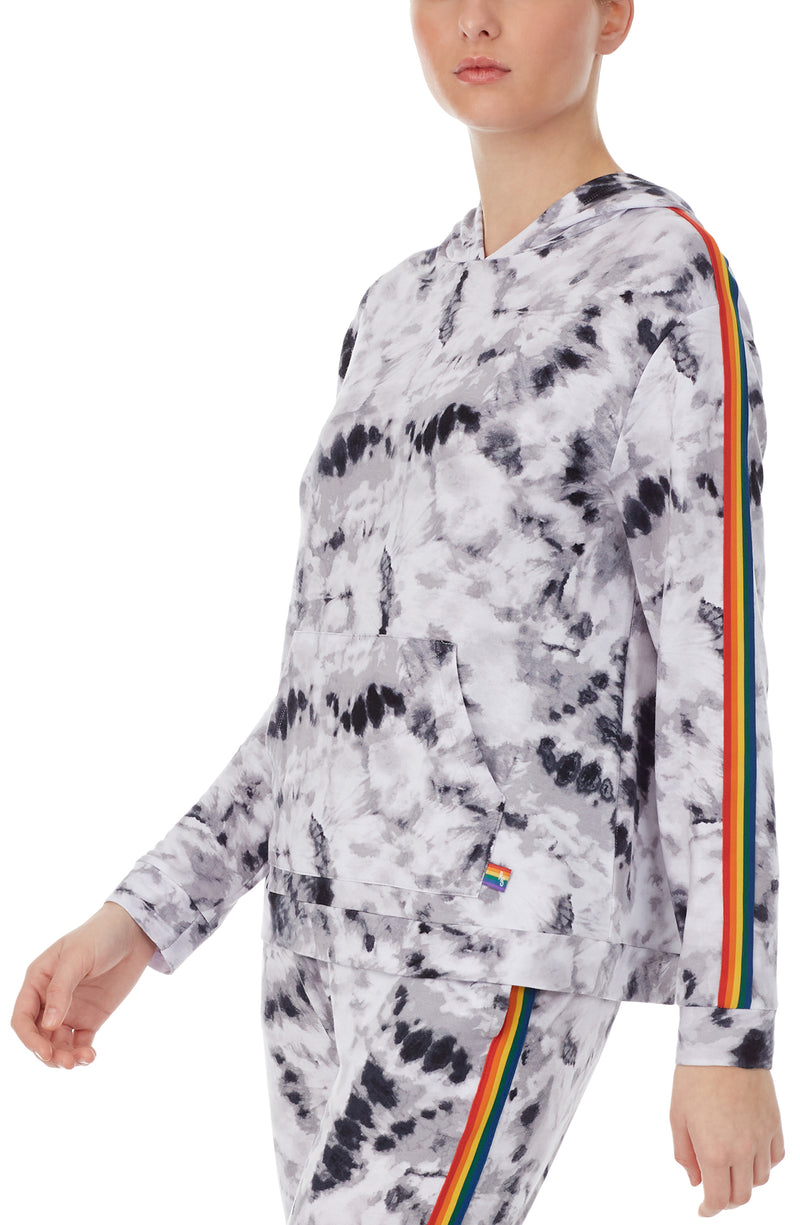 A lady wearing a long sleeve reese unisex hoodie with black and white tiedye with pride stripes in side.