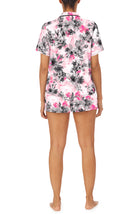 A lady wearing a short sleeve notch top and boxer pj set with pink watercolor floral pattern.