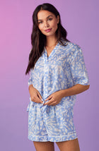 A lady wearing blue short sleeve abbey pj set with beach please coral print.