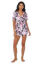 A lady wearing a short sleeve notch top and boxer pj set with pink watercolor floral pattern.