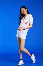 A lady wearing a white unisex pj set with midnight lightning pattern.
