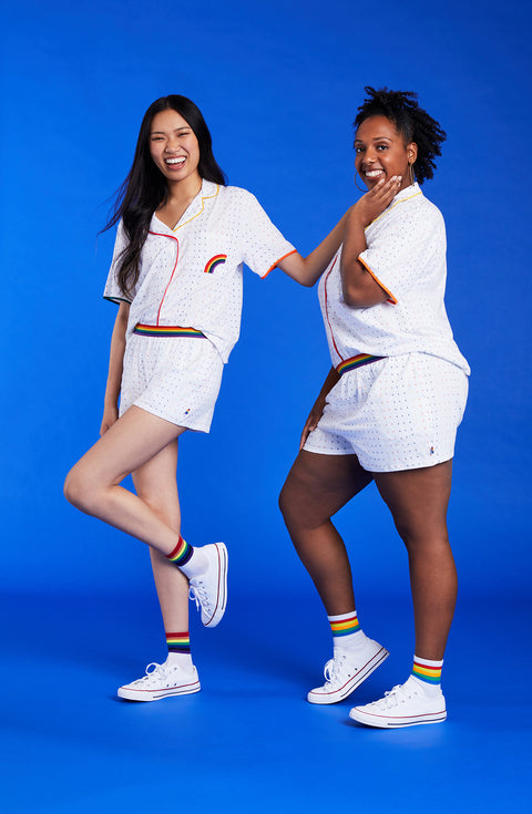 Two ladys wearing a white unisex pj set with midnight lightning pattern.