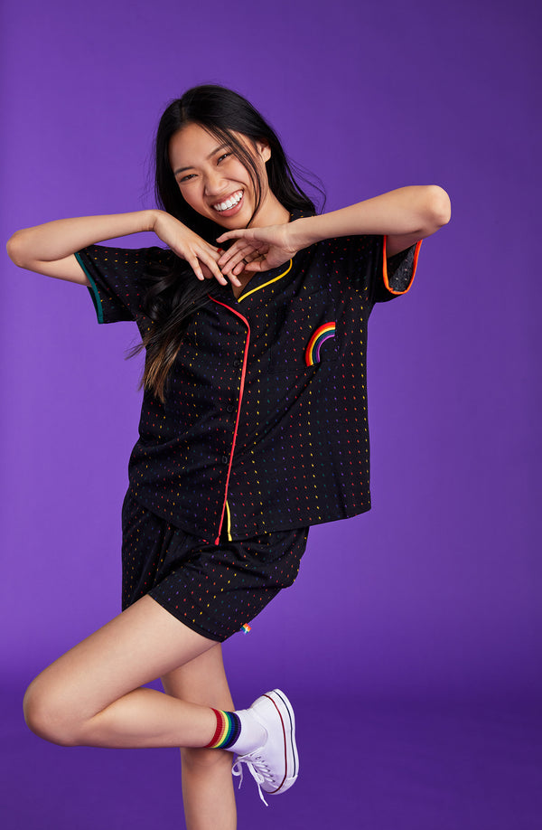 A lady wearing a black unisex pj set with midnight lightning pattern.