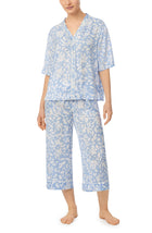 A lady wearing blue short sleeve tiden pj set with beach please coral print. 