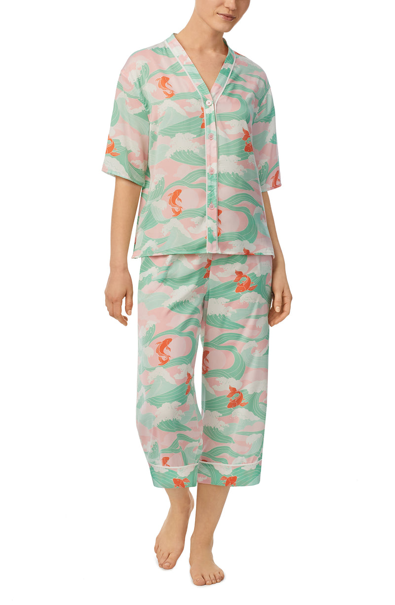 A lady wearing multi color short sleeve tilden pj set with catching waves print.