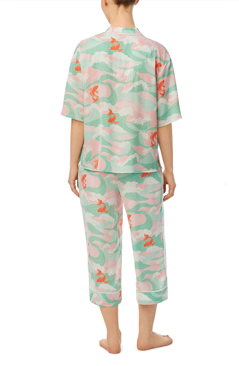 A lady wearing multi color short sleeve tilden pj set with catching waves print.