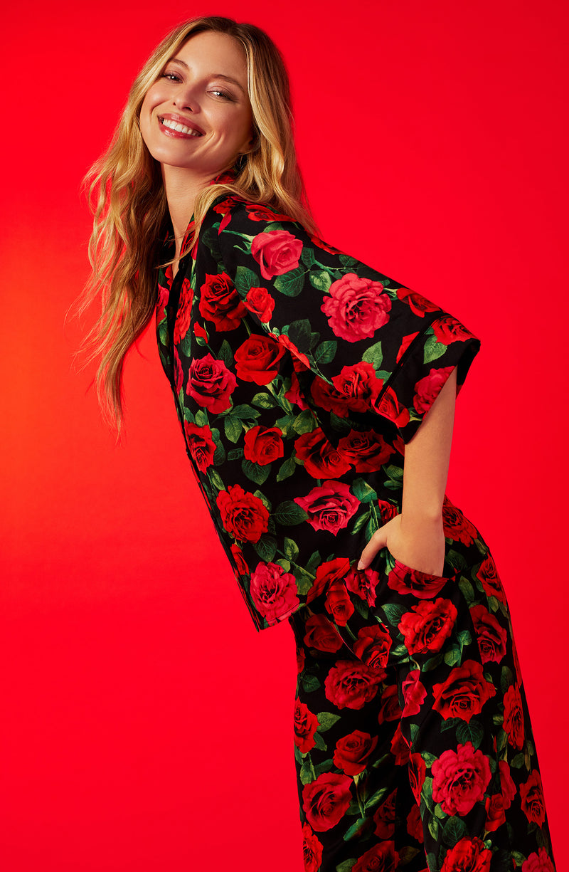 A lady wearing a black short sleeve top with red rose flowers pattern.