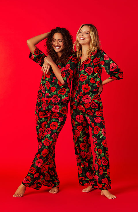 Two ladies wearing a black short sleeve top with red rose flowers pattern.