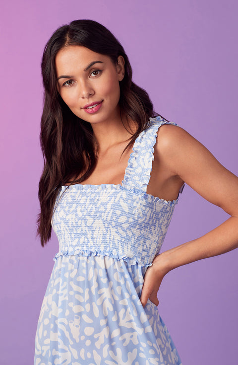 A lady wearing blue willow chemise with beach please coral print.