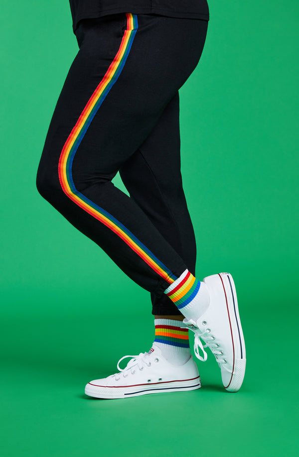A lady wearing a black unisex jogger with pride stripe in side.