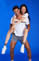 A lady and a man  wearing a white unisex T-Shirt with pride stripes.